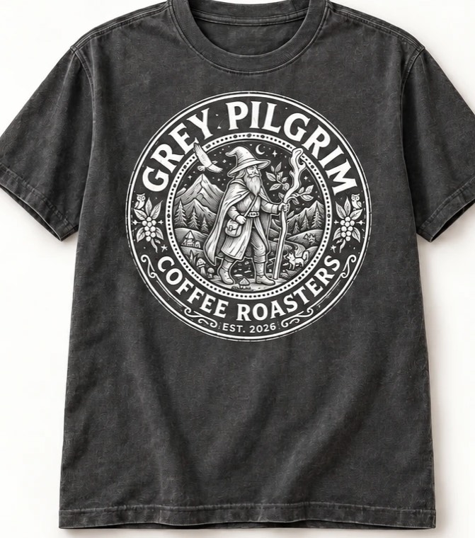 The Badge Tee in Washed Charcoal — the full badge printed front-center in a single ink